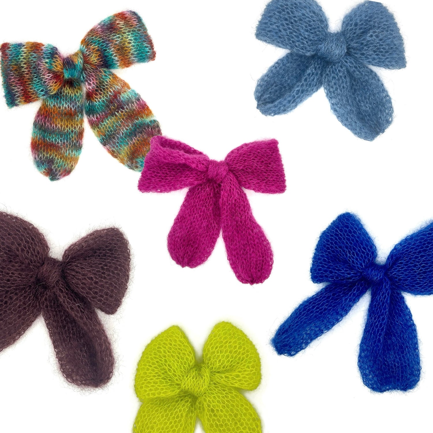 6 knitted mohair bows - neon green, electric blue, chocolate brown, raspberry pink, cornflower blue and rainbow - scattered across a white background