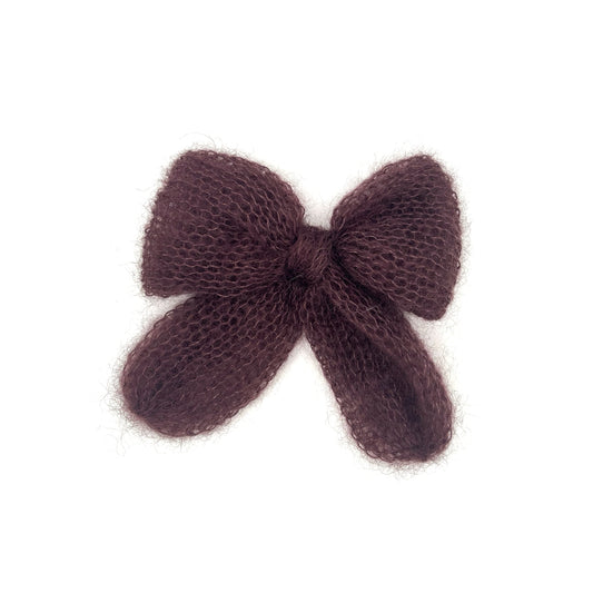 A plum knitted mohair bow on a white background