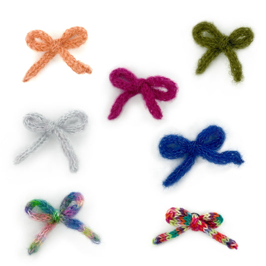 Small knitted bow handmade Crocs charms of various colours on a white background. Bow Croc Charms - Starpot Studio