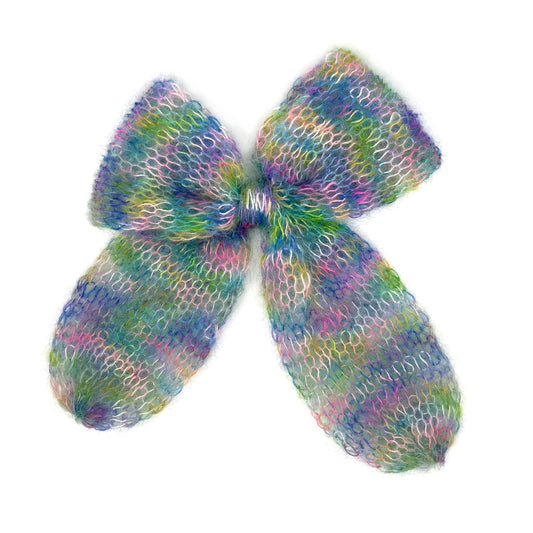 Lake Kingdom - Starpot Studio. Blue, pink, green and yellow tie-dye knitted bow on a white background